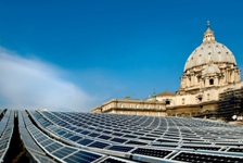 Fotovoltaický systém na střeše Auly Pavla VI. ve Vatikánu, v pozadí kopule baziliky