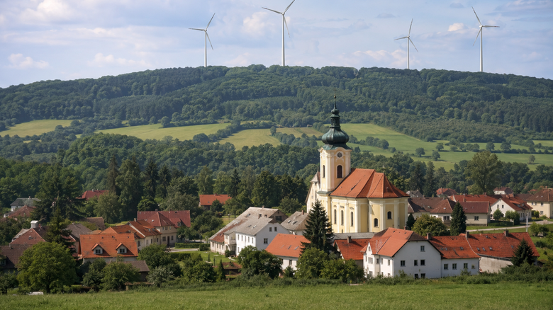 Obec a větrná elektrárna. AI generovaný obrázek. Foto © TZB-info